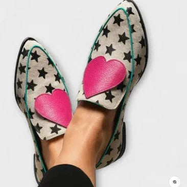 White low heel pointed-toe women's shoes with heart and star details on a solid background