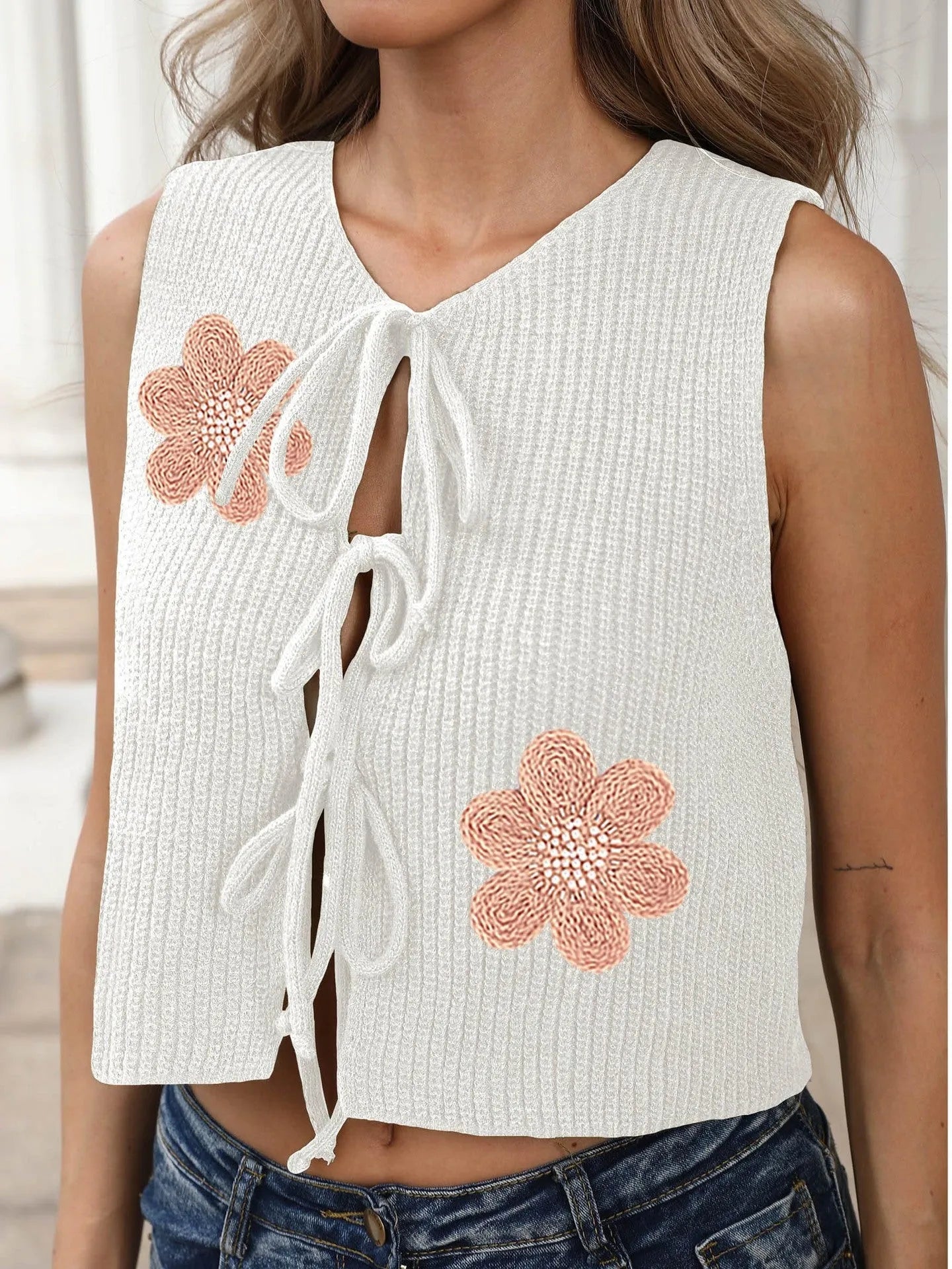 Short white sleeveless cardigan vest for women with lace-up bows and a flower pattern.