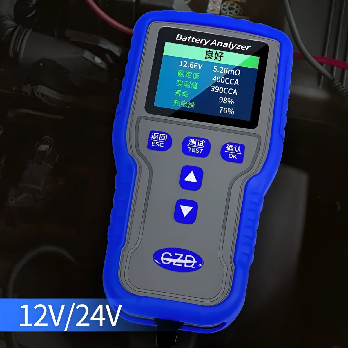 TKM016 car battery tester on a workbench, showing its compact 167x86x32mm size and handheld design