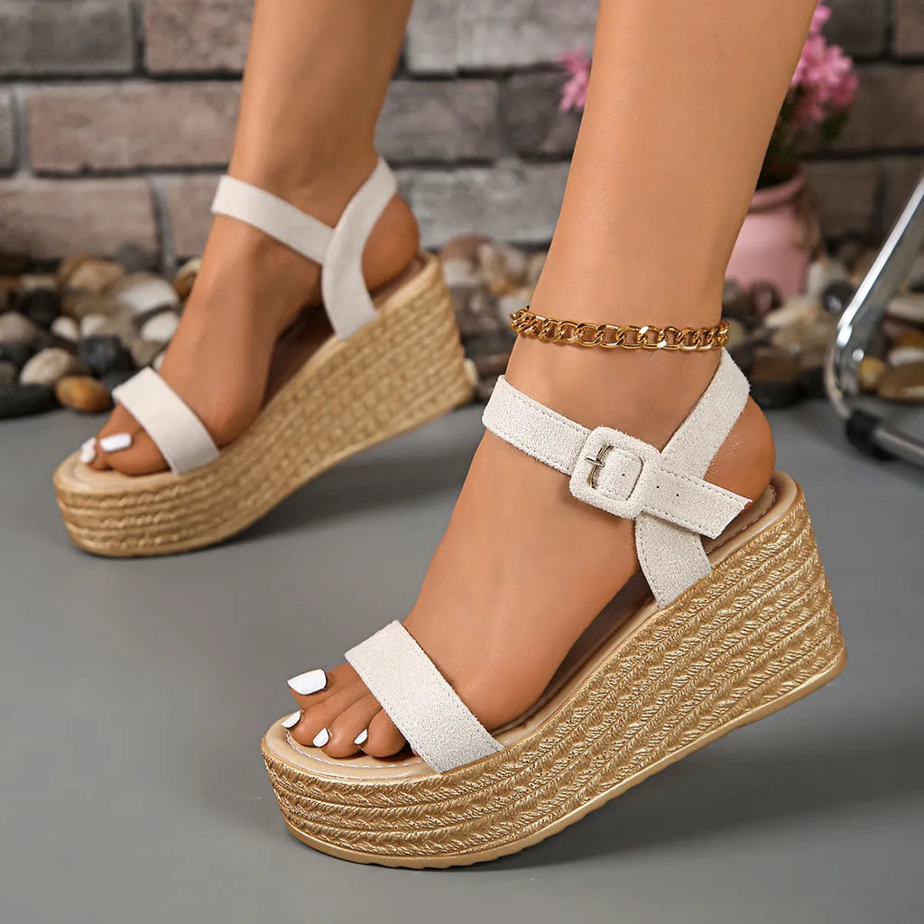 Beige women's suede platform wedge sandals with round toe and buckle closure on a light background