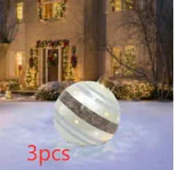 Large red and white striped inflatable Christmas ball ornament hanging on an outdoor tree