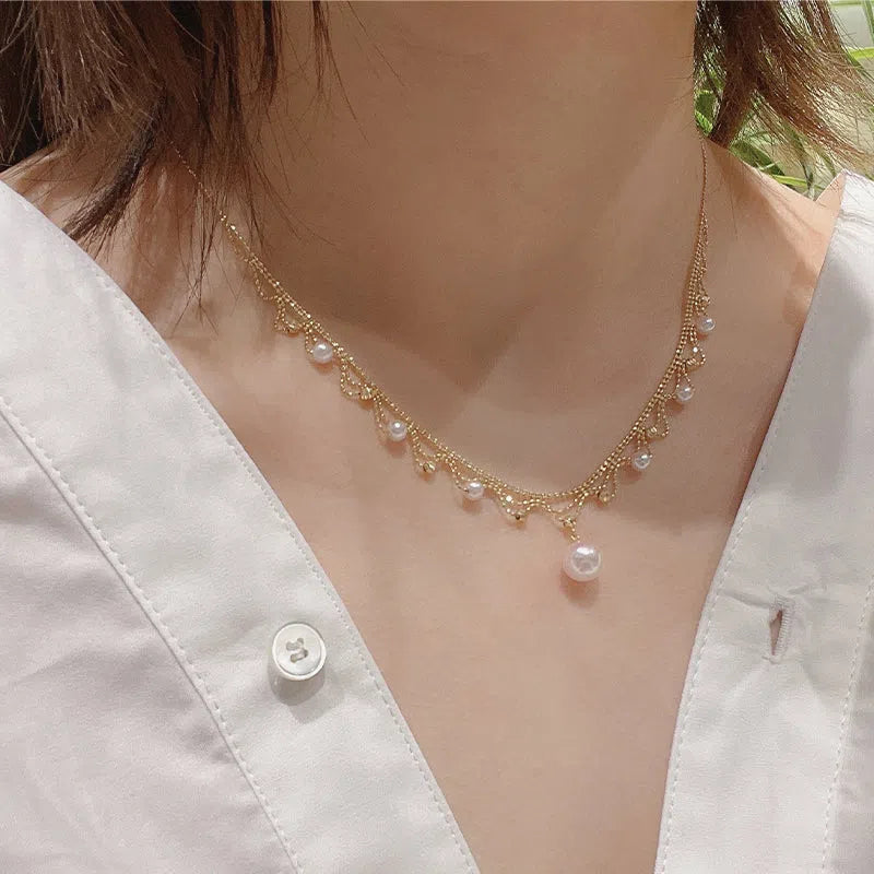 Aurora Japanese 18k gold lace pearl necklace with round sea pearl and gold finish on display