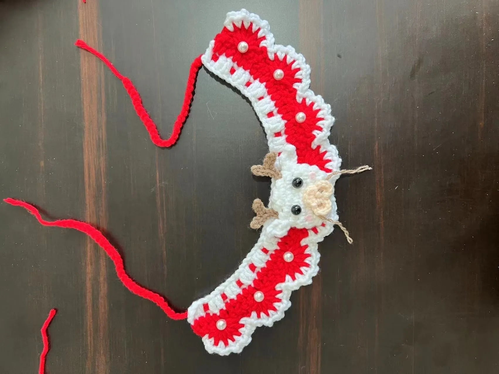 Knitted wool Christmas scarf for pets featuring festive patterns like striped Santa and elk, shown attached to a dog collar.
