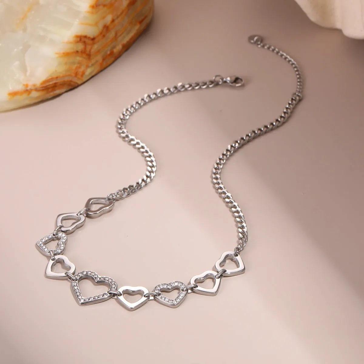 Geometric heart-shaped stainless steel pendant necklace with 18K gold finish on clavicle-length regular chain
