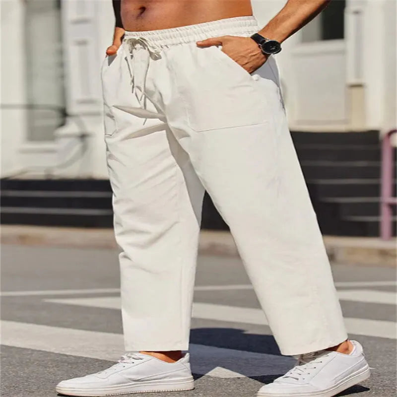 Men's straight-leg linen trousers in a solid colour, showing the elasticated mid waist and long leg.