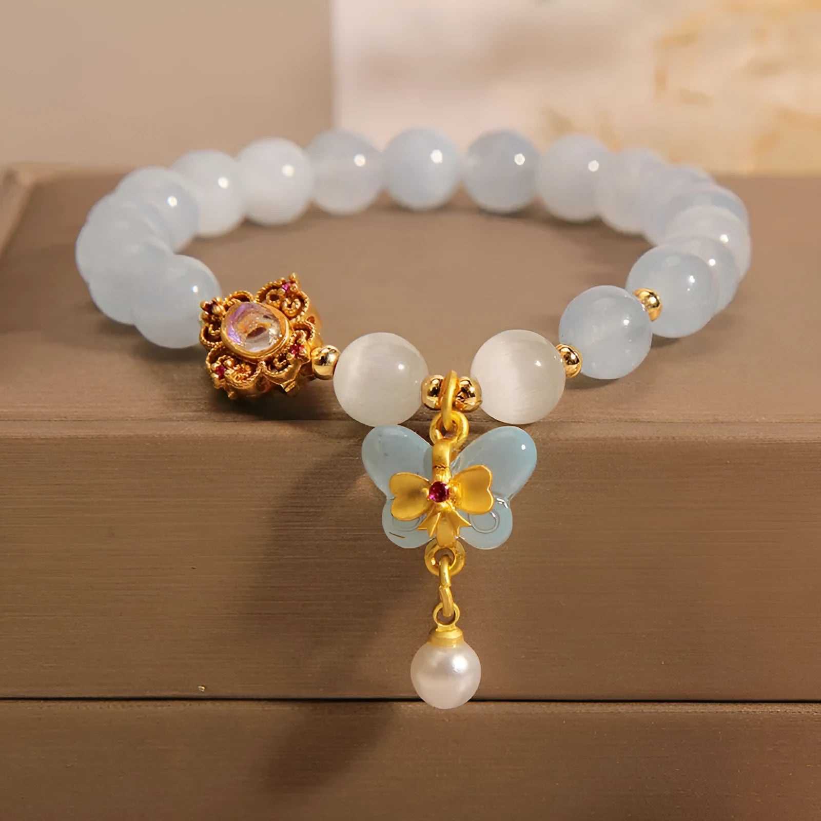 Women's crystal bracelet with aquamarine butterfly pendant and rhinestone decoration