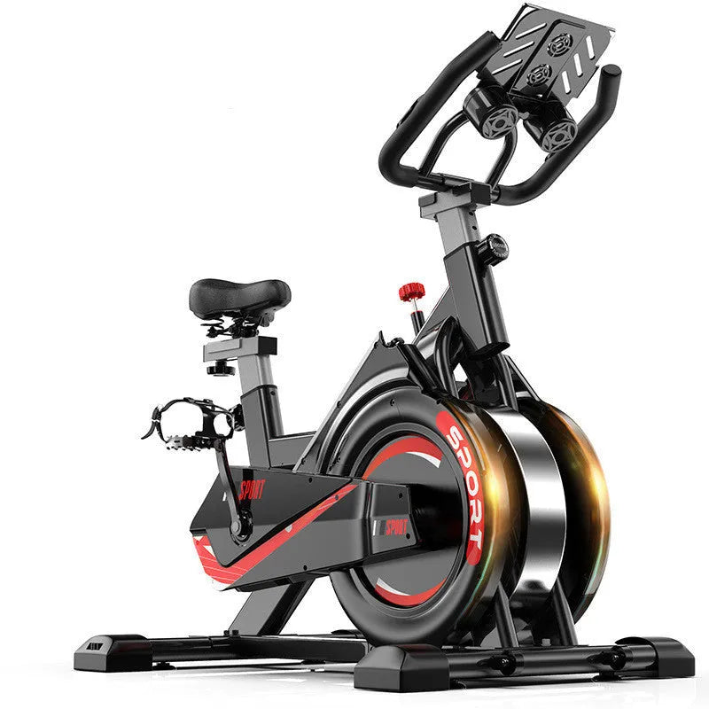 Black upright spinning bike with console and infinite resistance knob on a home gym floor