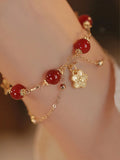 Women's double layer bracelet made from natural red agate with peach blossom decorations.