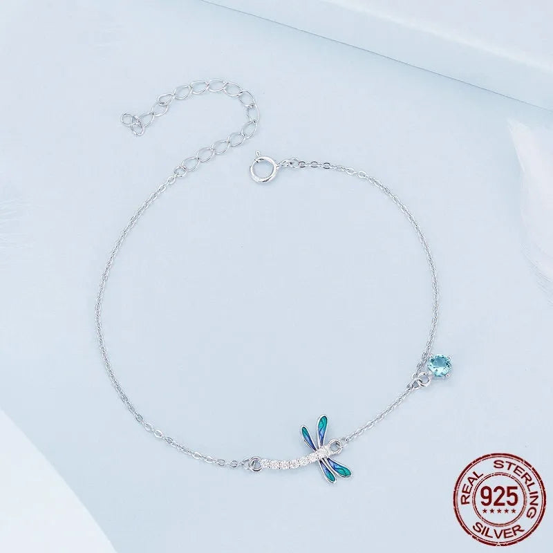 Sterling silver white gold plated dragonfly bracelet with dripping zircon stones on white background