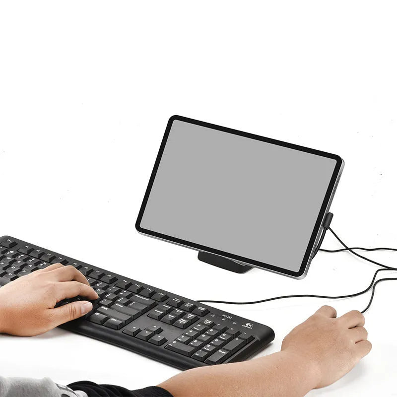 Black USB-C docking station with integrated bracket stand for laptops, featuring USB and HDMI ports, on a desk