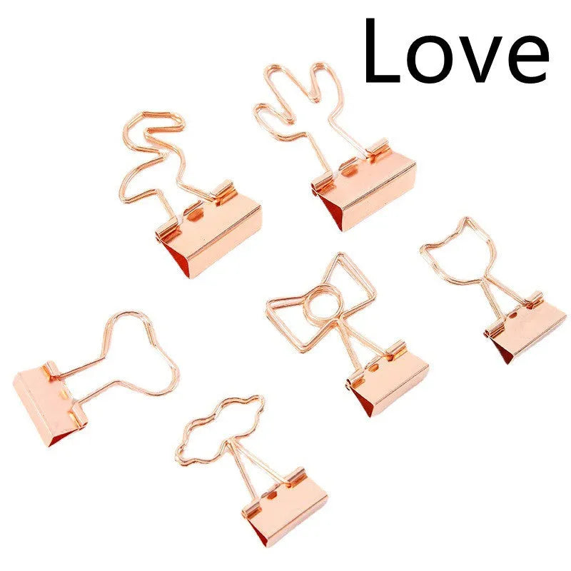Small gold-plated metal office clip with a long tail, shown in a choice of flamingo, love, clouds, cat, and cactus shapes.
