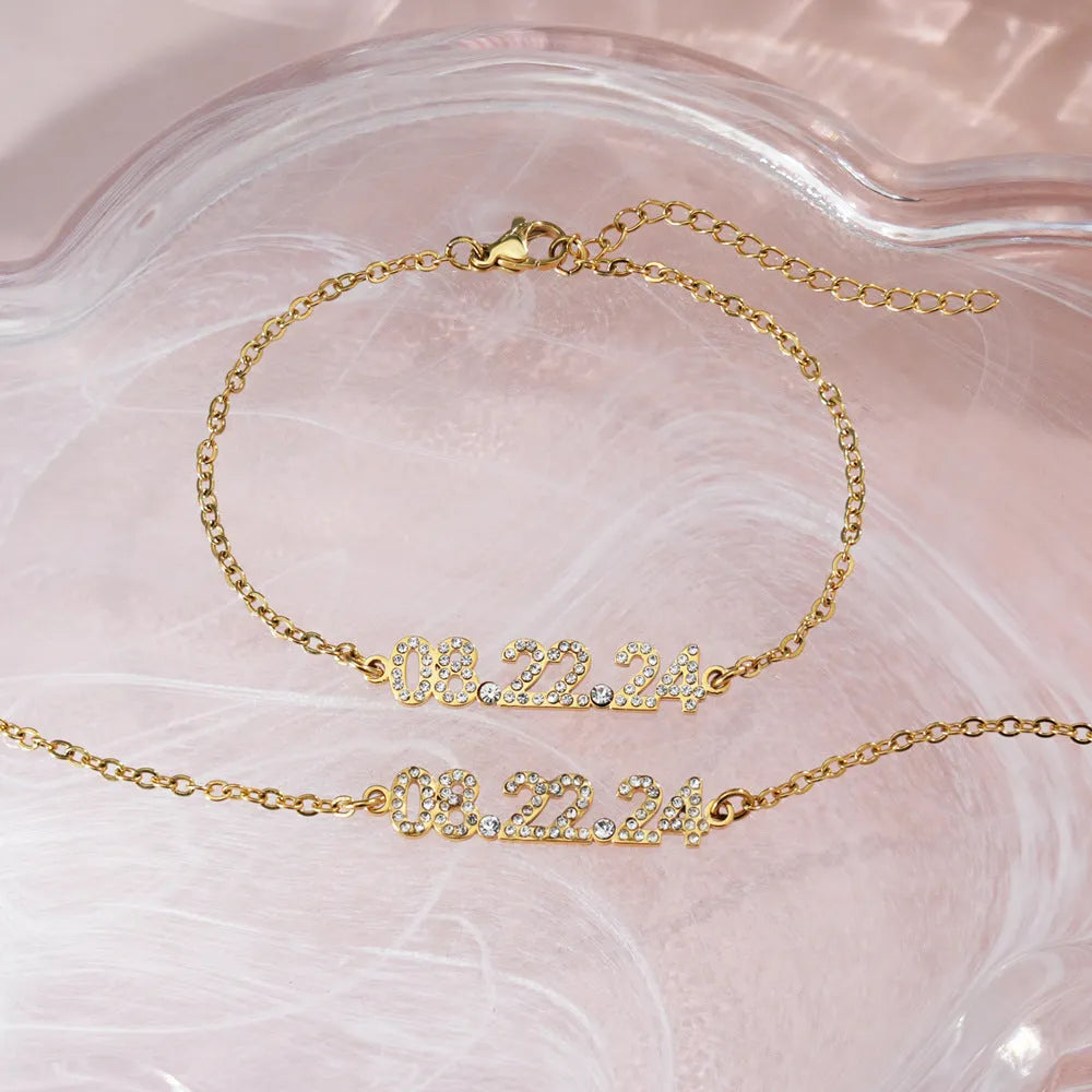Stainless steel digital bracelet with diamond-studded numbers in gold finish on wrist.