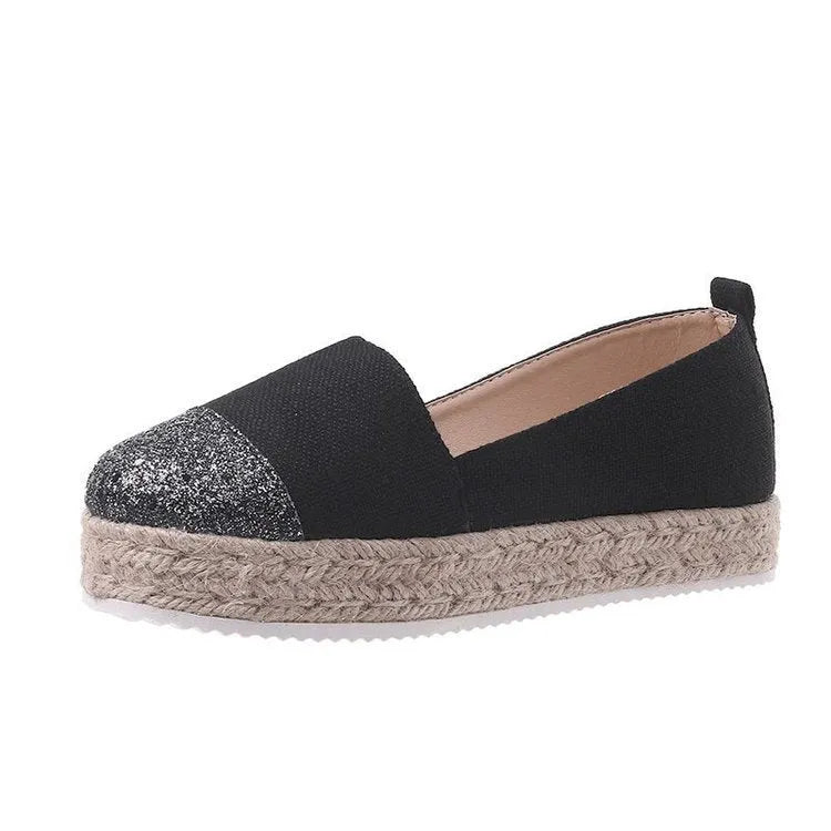 Women's plus size black canvas slip-on flat shoes with round toe, shown from the side.