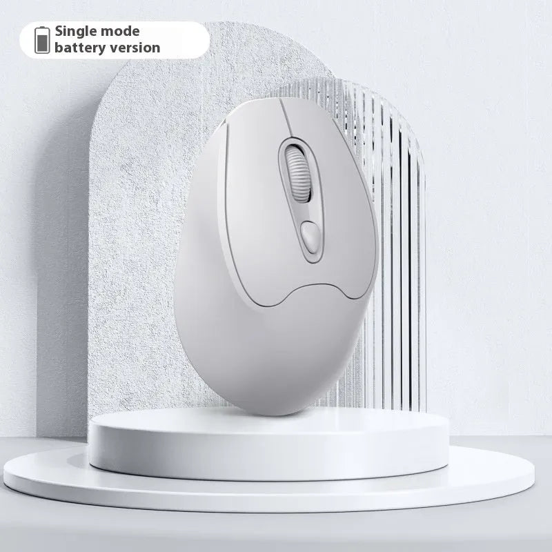 Bluetooth wireless mouse in choice of girl pink, milk tea pink, grey or green colours on a desk next to a laptop.