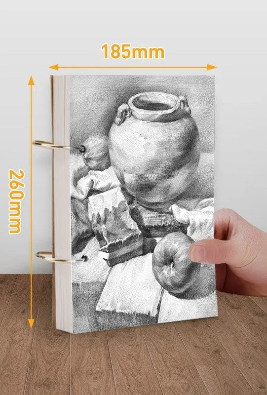 8K thickened sketchbook open on a table with marker drawings, showing linen and black card cover options.
