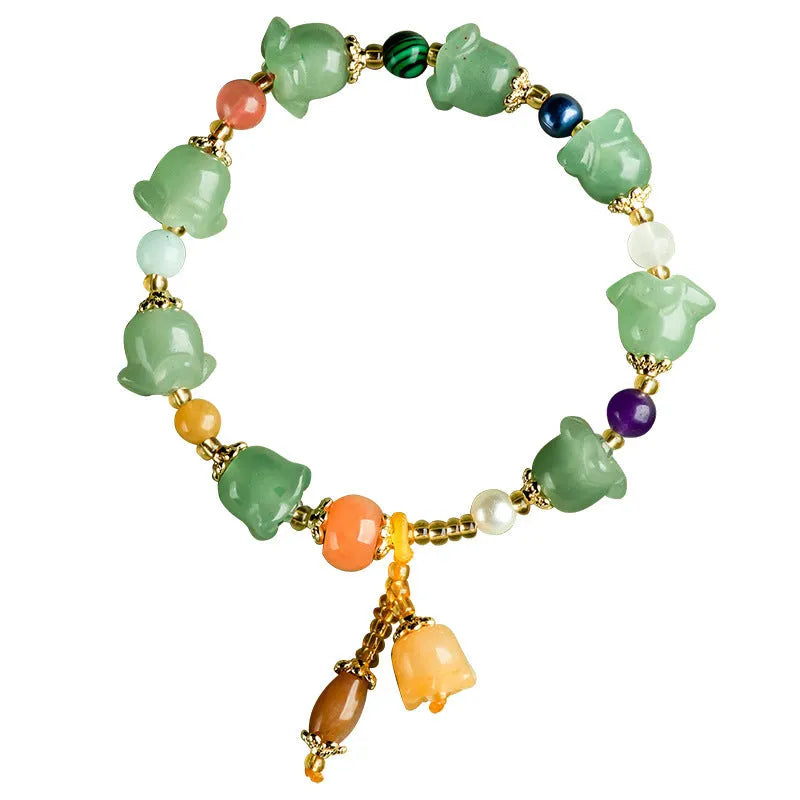 Natural Jinsi Jade bracelet with carved orchid beads on a wrist.