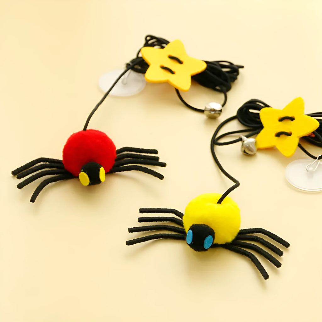 Red and yellow feather cat toy hanging from door on elastic rope with bell spider element for indoor feline play
