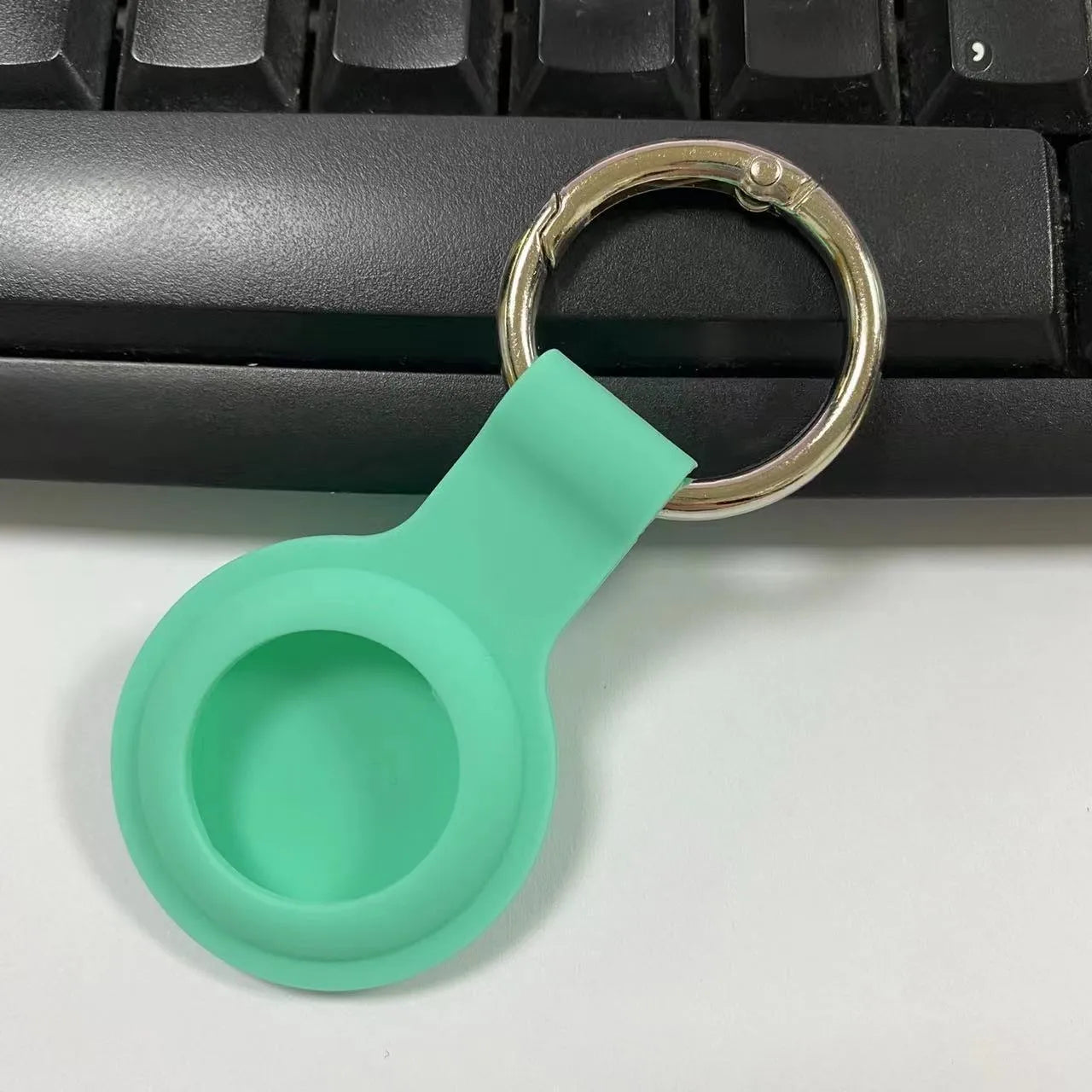 Silicone protective case with metal keychain snap for Apple AirTag in multiple colours.